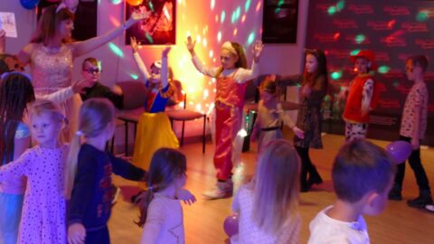 Na zdjęciu tańczące dzieci w kolorowych strojach bohaterów bajek