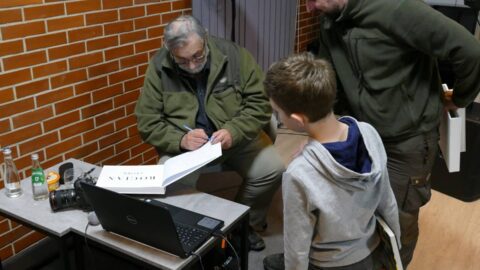 Na zdjęciu Tomasz Kłosowski podpisujący książki uczestnikom spotkania
