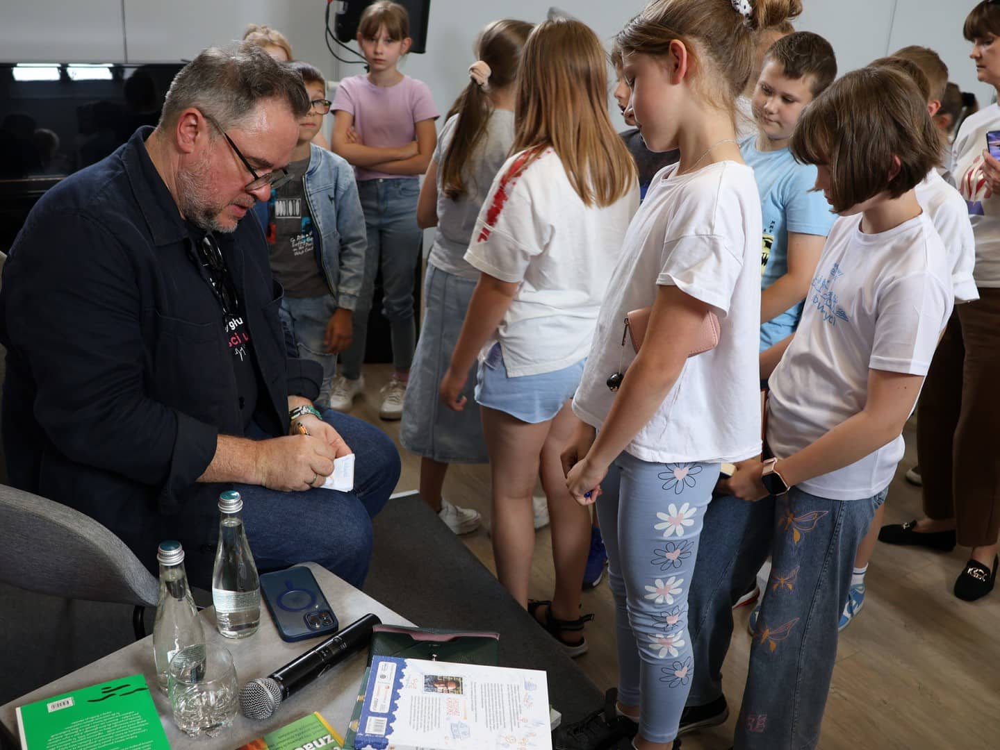 Na zdjęciu Grzegorz Kasdepke podpisujący książki uczestnikom spotkania