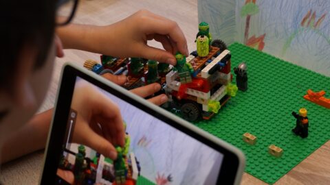 Na zdjęciu tablet rejestrujący scenę do filmiku poklatkowego z pojazdem z klocków Lego